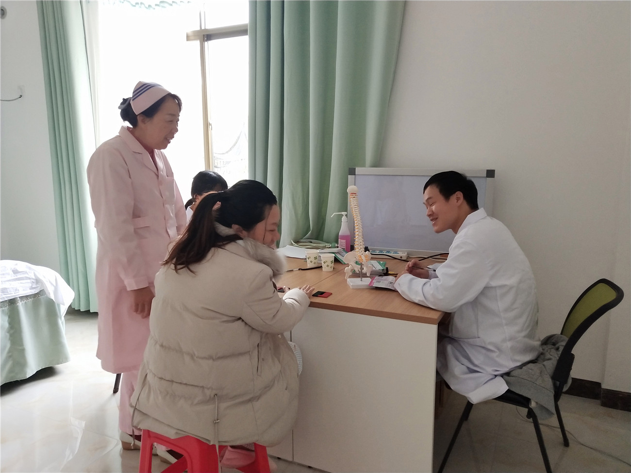 0112宝妈在接受广西骨伤医院专家团队的诊疗，护长陈丽棠陪同.jpg